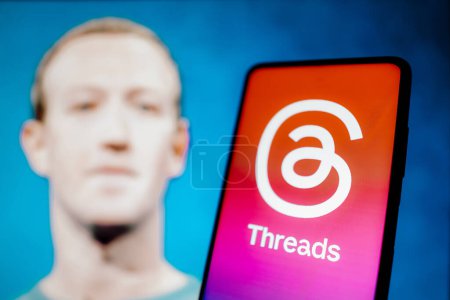 Photo for July 7, 2023, Brazil. In this photo illustration, the Threads logo is displayed on a smartphone screen. In the background, the image of Mark Zuckerberg, creator of the social network - Royalty Free Image
