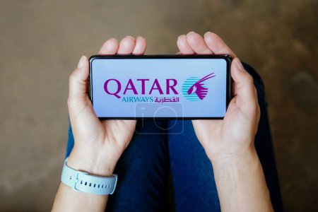 Téléchargez les photos : July 20, 2023, Brazil. In this photo illustration, the Qatar Airways logo seen displayed on a smartphone - en image libre de droit