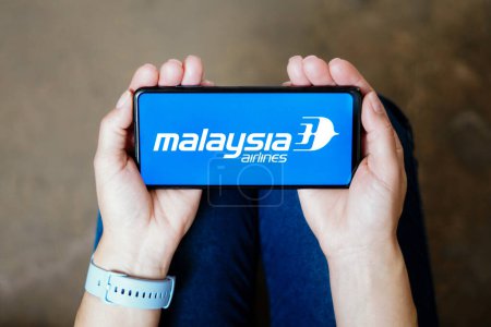 Foto de July 20, 2023, Brazil. In this photo illustration, the Malaysia Airlines logo seen displayed on a smartphone - Imagen libre de derechos