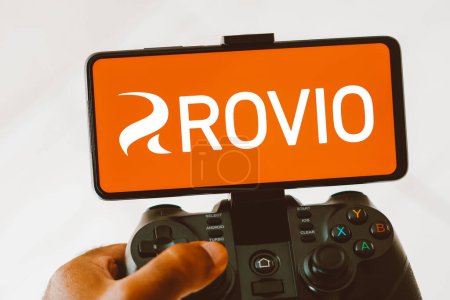 Foto de 9 de agosto de 2023, Brasil. En esta ilustración fotográfica, una persona que juega en un joystick y el logotipo de Rovio Entertainment Corporation se muestran en la pantalla de un teléfono inteligente - Imagen libre de derechos