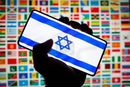 Téléchargez les photos : 12 octobre 2023, Brésil. Dans cette illustration photo, le drapeau d'Israël est affiché sur un écran de smartphone et en arrière-plan les drapeaux de plusieurs pays - en image libre de droit