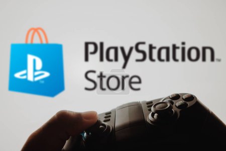Photo for December 4, 2023, Brazil. In this photo illustration, the PlayStation Store logo game is displayed on a computer screen, next to a gamepad - Royalty Free Image