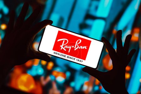 Foto de 13 de diciembre de 2023, Brasil. En esta ilustración fotográfica, el logotipo de Ray-Ban se muestra en la pantalla de un teléfono inteligente - Imagen libre de derechos