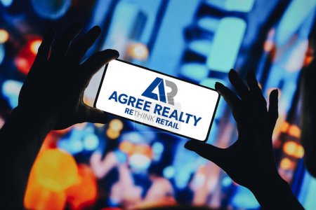 Foto de 15 de enero de 2024, Brasil. En esta ilustración fotográfica, el logotipo de Agree Realty Corporation se muestra en la pantalla de un teléfono inteligente - Imagen libre de derechos