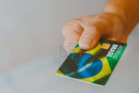 Foto de 17 de enero de 2024, Brasil. En esta foto ilustración una mujer con la tarjeta Auxlio Brasil (Bolsa Famlia). - Imagen libre de derechos