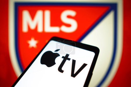 Téléchargez les photos : 23 janvier 2024, Brésil. Dans cette illustration photo, le logo Apple TV est affiché sur un écran de smartphone et le logo Major League Soccer (MLS) en arrière-plan. - en image libre de droit