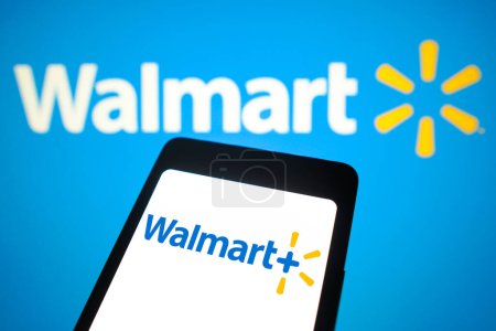 Foto de 21 de febrero de 2024, Brasil. En esta ilustración fotográfica, el logotipo de Walmart Plus se muestra en la pantalla de un teléfono inteligente y en el fondo, el logotipo de Walmart - Imagen libre de derechos