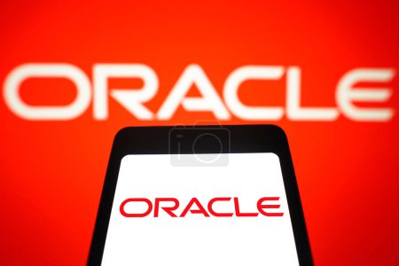 Foto de 12 de marzo de 2024, Brasil. En esta ilustración fotográfica, el logotipo de Oracle Corporation se muestra en la pantalla de un teléfono inteligente y en el fondo - Imagen libre de derechos