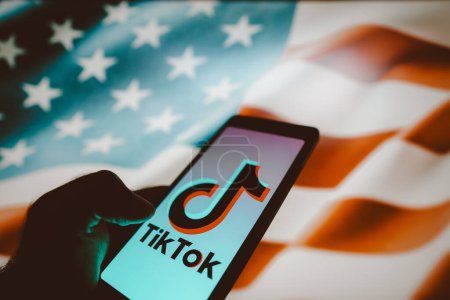 Photo for March 14, 2024, Brazil. In this photo illustration, the TikTok logo is displayed on a smartphone screen with the flag United States (US) in the background - Royalty Free Image