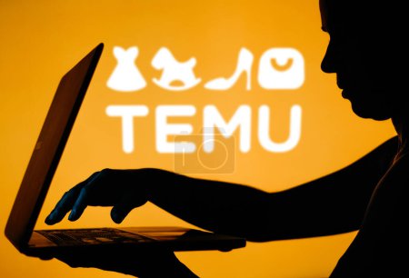 Foto de 28 de marzo de 2024, Brasil. En esta ilustración fotográfica, el logotipo de Temu se ve en el fondo de una silueta de una persona usando un cuaderno - Imagen libre de derechos