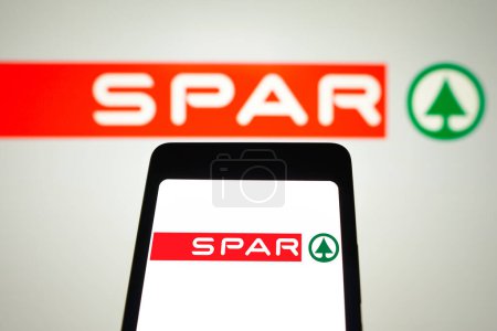 Photo for March 31, 2024, Brazil. In this photo illustration, the SPAR logo is displayed on a smartphone screen and in the background - Royalty Free Image