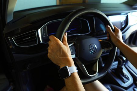 Photo for April 20, 2024, Brazil. In this photo illustration, the app driver holds the steering wheel of the Volkswagen car. In Brazil, the government is seeking to regulate app-based work - Royalty Free Image