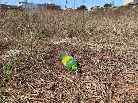 Foto de May 4, 2024, Brazil. Plastic bottle thrown in a vacant lot accumulating dirt. A suitable breeding ground for the Aedes aegypti mosquito, which transmits the dengue, zika and chikungunya viruses. - Imagen libre de derechos
