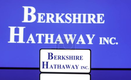 Foto de 6 de mayo de 2024, Brasil. En esta ilustración fotográfica, el logotipo de Berkshire Hathaway se muestra en una pantalla de teléfono inteligente y en el fondo. - Imagen libre de derechos