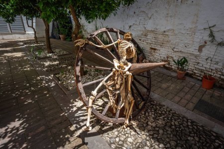 Téléchargez les photos : Grenade, Espagne - 6 juin 2019 : Squelette dans une roue écrasante au Musée de l'Inquisition au Palais des Oubliés (Palacio de los Olvidados) - Grenade, Andalousie, Espagne - en image libre de droit