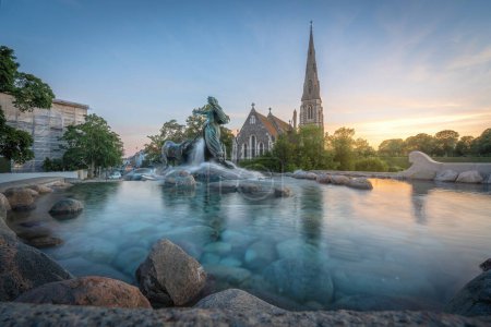 Téléchargez les photos : Copenhague, Danemark - 28 juin 2019 : Fontaine Gefion et église St. Albans au coucher du soleil - Copenhague, Danemark - en image libre de droit