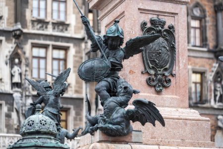 Téléchargez les photos : Munich, Allemagne - 30 oct. 2019 : Putto combattant un dragon représentant la faim ou la famine - Sculpture Mariensaule sur la place Marienplatz - Munich, Bavière, Allemagne - en image libre de droit