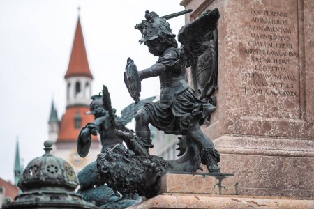 Foto de Munich, Alemania - 30 de octubre de 2019: Putto luchando contra un león que representa la guerra - Mariensaule Sculpture at Marienplatz Square - Munich, Baviera, Alemania - Imagen libre de derechos