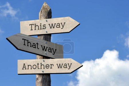 This way, that way, another way - wooden signpost with three arrows, sky with clouds