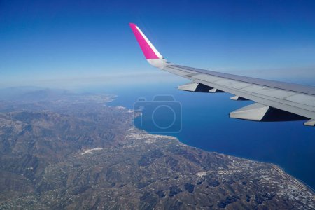 Photo for Flying over coast of Spain - plane wing and sea coast - Royalty Free Image