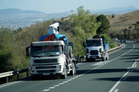 Foto de Dos camiones con equipo de construcción en una carretera - vista frontal - Imagen libre de derechos