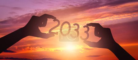 Photo for 2033 - human hands holding black silhouette year number - Royalty Free Image