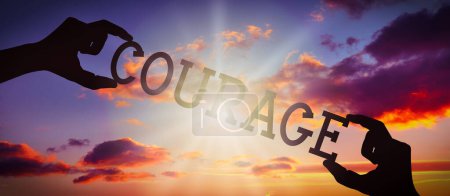 Photo for Courage - human hands holding black silhouette word - Royalty Free Image