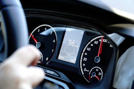 Speedometer and hands on a steering wheel - driving at 96 kmh