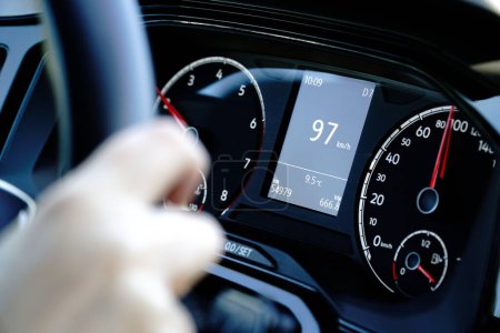 Speedometer and hands on a steering wheel - driving at 97 kmh