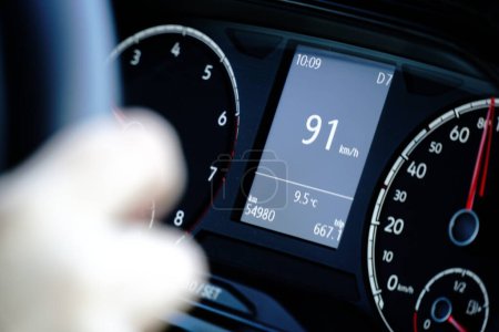 Speedometer and hands on a steering wheel - driving at 91 kmh