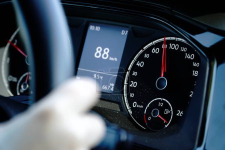 Speedometer and hands on a steering wheel - driving at 88 kmh