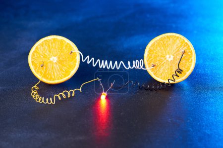 Photo for Free energy electricity generator using oranges in blue light. - Royalty Free Image