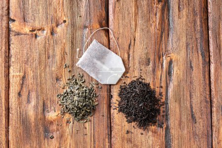 Photo for Tea bag, green and black tea on an old wooden table. - Royalty Free Image