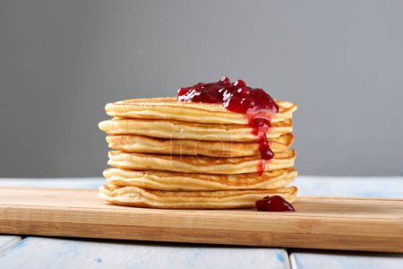 Photo for Pancakes with red berry jam on the wooden table. - Royalty Free Image