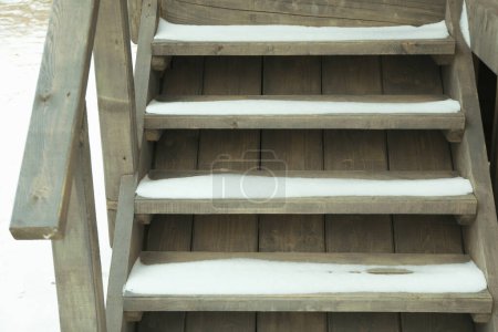 Téléchargez les photos : Escaliers en bois avec neige de maison en bois confortable en plein air - en image libre de droit