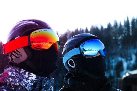 Two skiers in ski helmets and masks outdoor