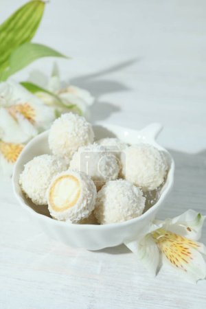 Téléchargez les photos : Concept of tasty sweets on white wooden table, coconut candies - en image libre de droit