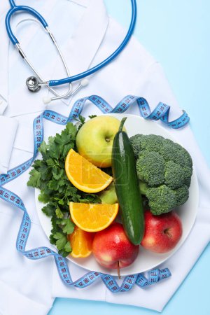 Téléchargez les photos : Aliments sains et accessoires pour médecins sur fond bleu - perte de poids - en image libre de droit