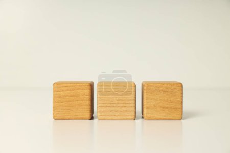 Photo for Three wooden cubes on white table, close up - Royalty Free Image
