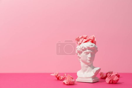 Foto de Cabeza antigua con bolas de papel sobre fondo rosa - Imagen libre de derechos
