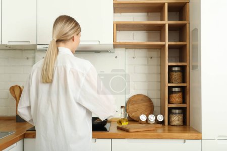 A young woman is preparing breakfast in the kitchen