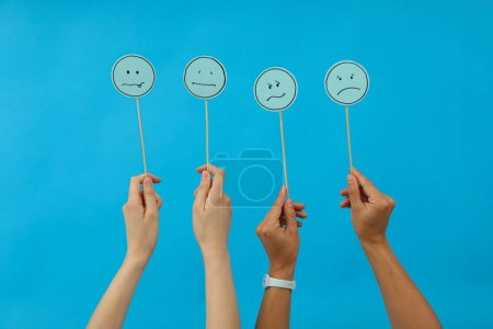 Photo for Sad emoji and hands on blue background - Royalty Free Image