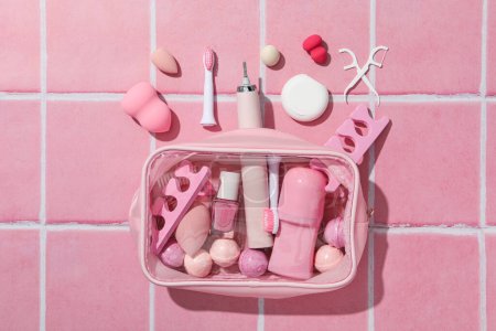 Téléchargez les photos : Brosse à dents électrique et sac cosmétique sur fond rose, vue de dessus - en image libre de droit
