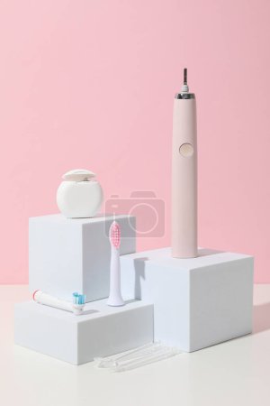 Téléchargez les photos : Brosse à dents électrique sur blocs sur fond rose - en image libre de droit