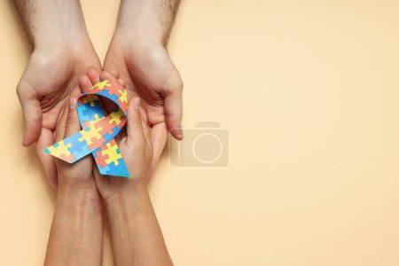 Photo for Ribbon with colorful puzzle pieces in hands on light background, place for text. World autism day concept - Royalty Free Image