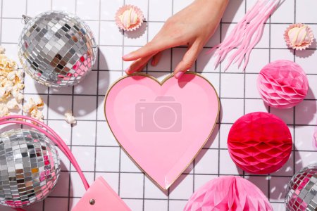 Photo for Disco balls, female hand and decorative heart on light background, top view - Royalty Free Image