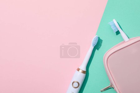 Téléchargez les photos : Brosses à dents électriques et étui sur fond rose, espace pour le texte - en image libre de droit