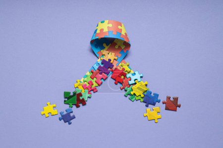 Photo for Ribbon with multi-colored puzzle pieces on a light background. World autism day concept - Royalty Free Image