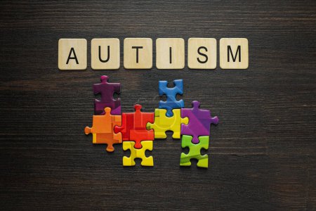 Photo for Multicolored puzzle pieces with the word "autism" on a black background. World autism day concept - Royalty Free Image