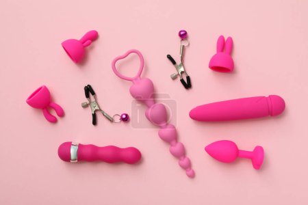 Kollektion von Sexspielzeug, auf rosa Hintergrund.